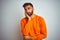 Young indian man wearing orange sweater over isolated white background thinking looking tired and bored with depression problems