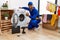 Young indian technician working on washing machine doing happy thumbs up gesture with hand