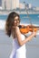 Young indian violin player on beach