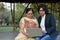 Young Indian woman helping her old retired mother on a laptop sitting in a park in New Delhi, India. Concept - Digital literacy /