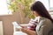 Young indian woman holding letter invoice reading bill at home.