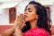 Young Indian woman in traditional sari red dress praying in a hindu temple goa india Hinduism.girl performing namaste