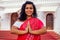 Young Indian woman in traditional sari red dress praying in a hindu temple goa india Hinduism.girl performing namaste