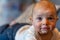 Young infant smiles and plays on his playmat