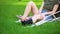 Young injured female with ankle supporting brace and crutches sitting park grass