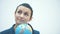 Young intelligent teacher stands on a white background. Holds the globe on the chin. Forgotten Close-up