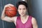 Young intense Asian male holding basketball