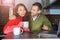 Young interesting couple looking at a laptop at home in the kitchen and holding a smartphone. An international couple on the Inter