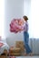 Young interior designer painting flower on wall in room