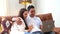 Young interracial couple relaxing on sofa with laptop. People in love and happiness leisure lifestyle at home together - Man and