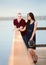 Young interracial couple standing together on wooden pier overlooking lake