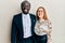 Young interracial couple wearing business and elegant clothes with a happy and cool smile on face