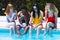 Young interracial people with mobile phones in the pool