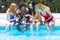 Young interracial people with mobile phones in the pool