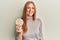 Young irish woman eating healthy rice crackers looking positive and happy standing and smiling with a confident smile showing