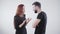 Young irritated Caucasian couple in black clothes arguing at white background. Handsome bearded man and beautiful