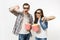 Young irritated couple, woman and man in 3d glasses and casual clothes watching movie film on date, holding buckets of