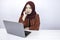 Young Islam woman is serious look with thinking gesture hand on face on the front of Laptop