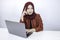 Young Islam woman is smiling face with thinking gesture looking on the blank space in the front of laptop