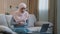 Young islamic arab business woman muslim girl in hijab sitting on sofa using laptop at home working studying online