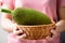 Young jackfruit in a basket holding by hand