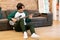 Young Japanese Musician Guy Practicing Electric Guitar In Living Room