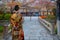 Young Japanese woman in traditional Kimono dress strolls on Tatsumi bashi bridge in Gion district, Kyoto, Japan