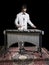 Young jazz musician playing the vibraphone in his private rehearsal room. Black background.