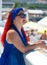 A young Jewess with African pigtails stands on the promenade against the background of the sea