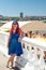 A young Jewess with African pigtails stands on the promenade against the background of the sea and the beach.