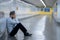 Young jobless business man suffering depression sitting on ground street underground leaning on wall alone looking desperate in