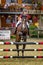 Young Jockey on horse at regional competition  jumping over obstacle