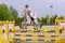 Young Jockey on horse at regional competition  jumping over obstacle