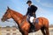 Young jockey horseback riding on purebred horse