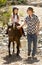 Young jockey kid riding pony outdoors happy with father role as horse instructor in cowboy look