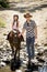 Young jockey kid riding pony outdoors happy with father role as horse instructor in cowboy look