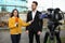 Young journalist interviewing businessman on street