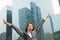 Young joyful businesswoman with arms outstretched among skyscrapers, Beijing