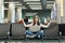 Young joyful traveler tourist woman with laptop sitting with crossed legs, meditate, spread hands, waiting in lobby hall