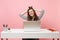 Young joyful woman clinging to hair, head finish working, complete project with pc laptop while sitting at office