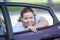 Young joyous beauty woman looking at opened car window