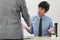 A young junior employee feels surprise and does not agree with his boss that abuses him about his work