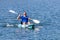 Young Kayaker Paddling Kayak. Sportsman kayaking Blue Water