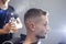 Young Kazakh barber works in a barbershop, a young guy makes a short haircut at a hairdresser, wet his head, water splashes on a