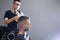 Young Kazakh barber works in a barbershop, a young guy makes a short haircut at a hairdresser, wet his head, water splashes on a