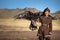 Young kazakh eagle hunter with his golden eagle