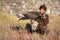 Young kazakh eagle hunter with his golden eagle