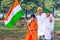 Young kids and boy of different age and different religion hearing tricolor dress and holding Indian National flag.