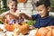 Young kids carving Halloween jack-o`-lanterns