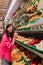 Young Korean woman shopping without plastic bags in grocery store. Vegan zero waste girl choosing fresh fruits and vegetables in